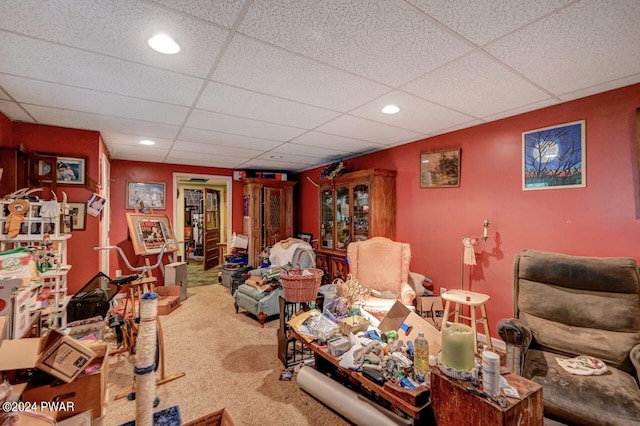 living room with carpet flooring and a paneled ceiling