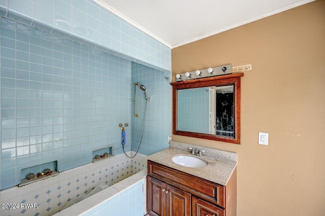 bathroom with crown molding, vanity, and tiled shower / bath combo