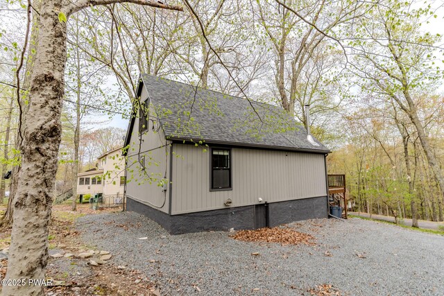 view of side of home with roof with shingles
