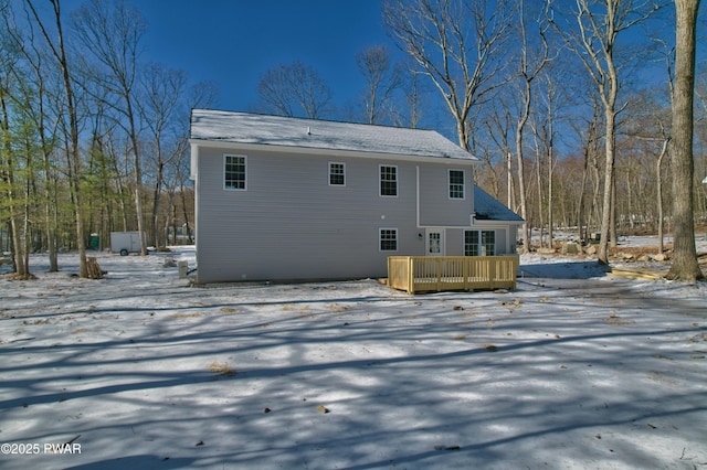 snow covered rear of property featuring a wooden deck