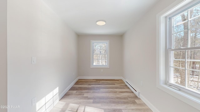 empty room with a baseboard radiator and light wood-type flooring