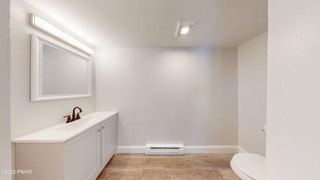 bathroom featuring vanity, a baseboard radiator, and toilet