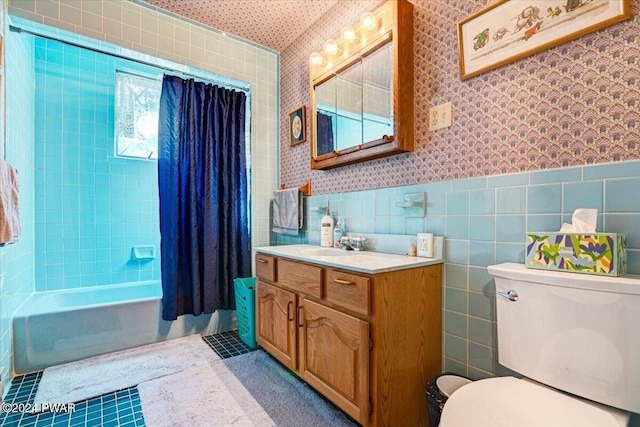 full bathroom with vanity, toilet, tile walls, and shower / tub combo