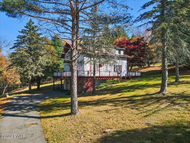 view of front of house featuring a front lawn and a wooden deck