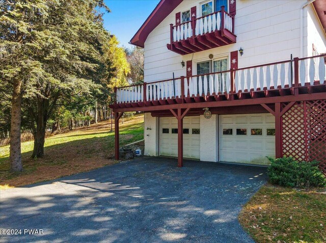 view of home's exterior with a garage and a balcony