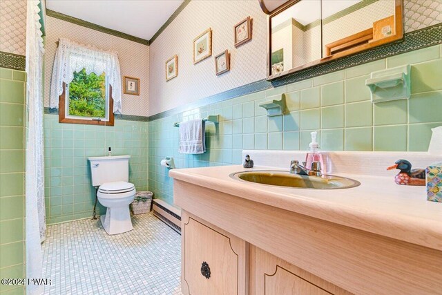 bathroom with tile patterned floors, ornamental molding, baseboard heating, tile walls, and toilet