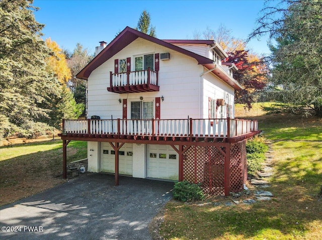 exterior space with a lawn, a garage, a balcony, and a wooden deck