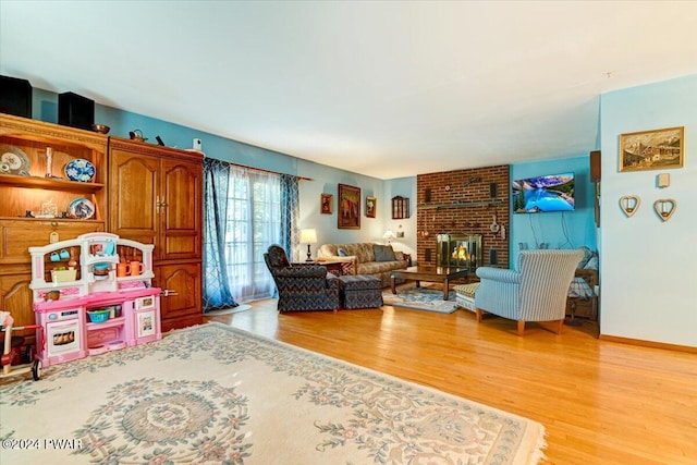 living room with a fireplace and light wood-type flooring