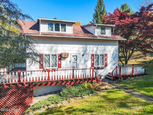 view of front of home featuring a front yard and a wooden deck