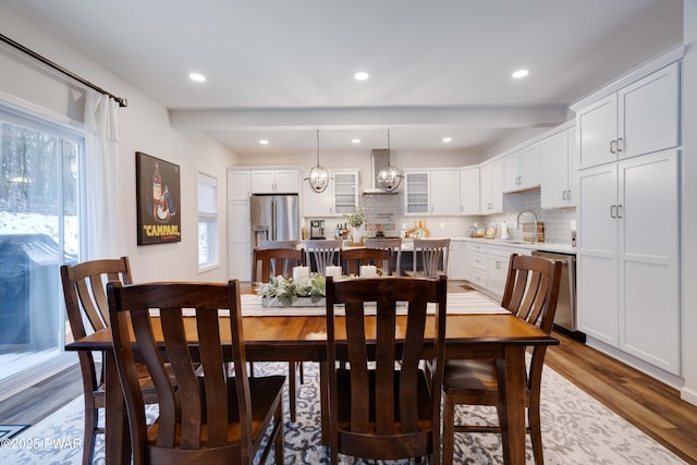 dining area featuring recessed lighting, beam ceiling, and wood finished floors