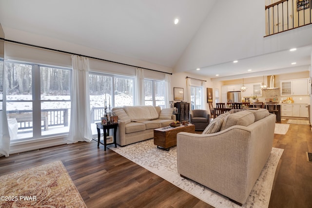 living area with dark wood-style floors, recessed lighting, visible vents, and high vaulted ceiling