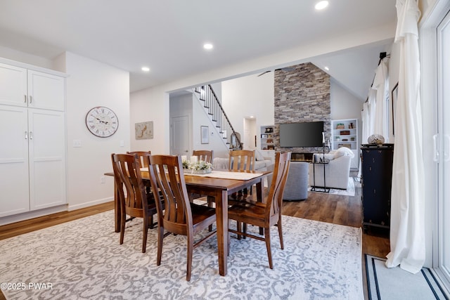 dining area with lofted ceiling, recessed lighting, stairway, and wood finished floors