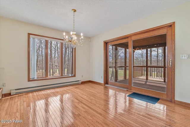 105 Beechwood Ln, Greentown, PA 18426 - spare room with baseboards, a baseboard heating unit, an inviting chandelier, a textured ceiling, and hardwood / wood-style floors