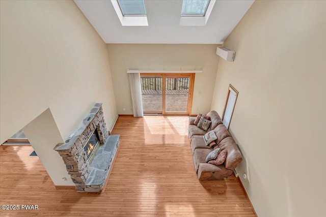 105 Beechwood Ln, Greentown, PA 18426 - living area featuring a skylight, high vaulted ceiling, hardwood / wood-style floors, and a stone fireplace