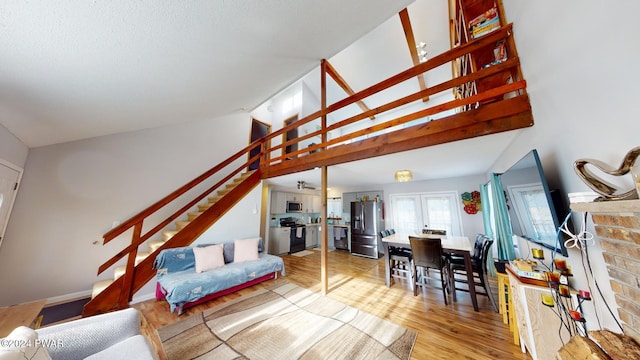 living room featuring french doors, light hardwood / wood-style floors, and lofted ceiling