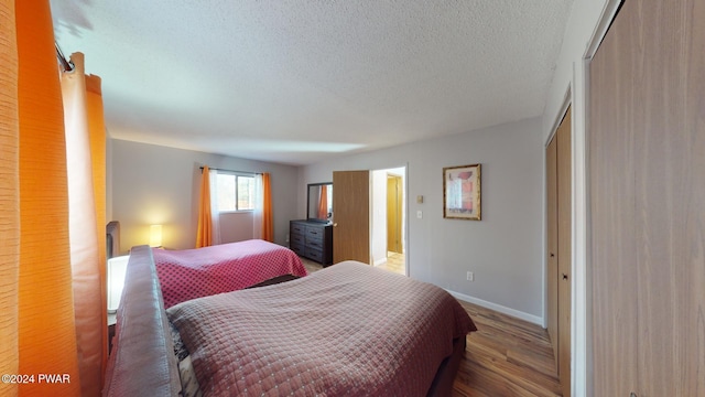 bedroom with hardwood / wood-style flooring and a textured ceiling