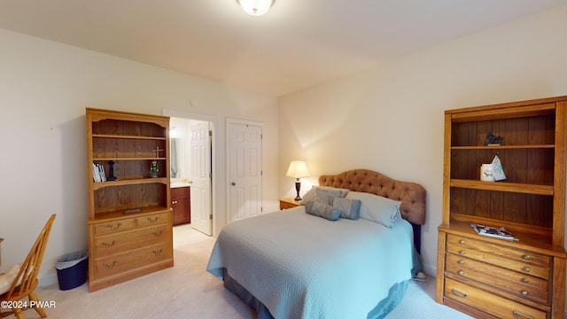 bedroom featuring ensuite bath and light colored carpet