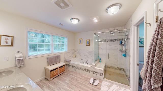 bathroom with wood-type flooring, vanity, and independent shower and bath