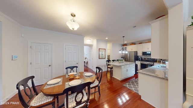 dining area with ornamental molding, dark wood-type flooring, and sink