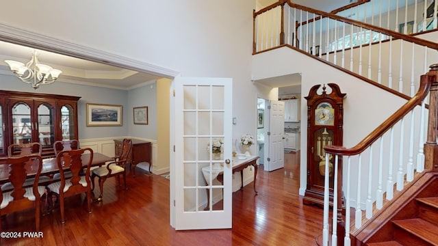 entrance foyer with crown molding, hardwood / wood-style flooring, and a notable chandelier