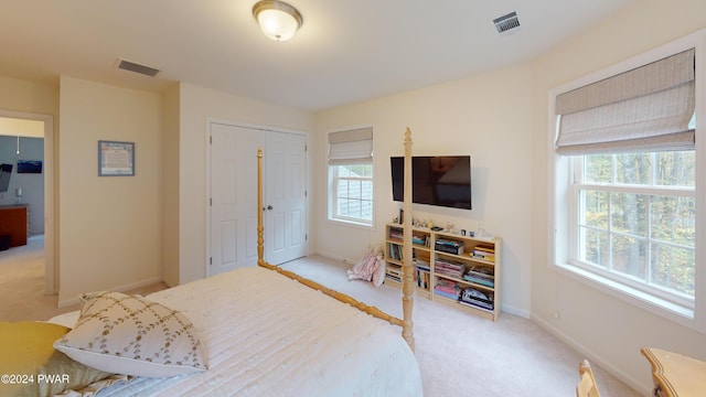 bedroom with light carpet and a closet