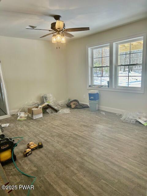 empty room with ceiling fan, baseboards, and wood finished floors