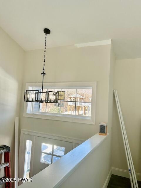 interior details with baseboards and a notable chandelier