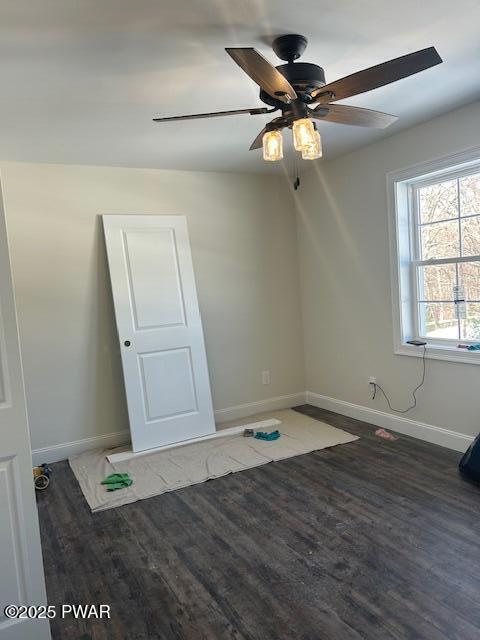 unfurnished room featuring dark wood-style flooring and baseboards