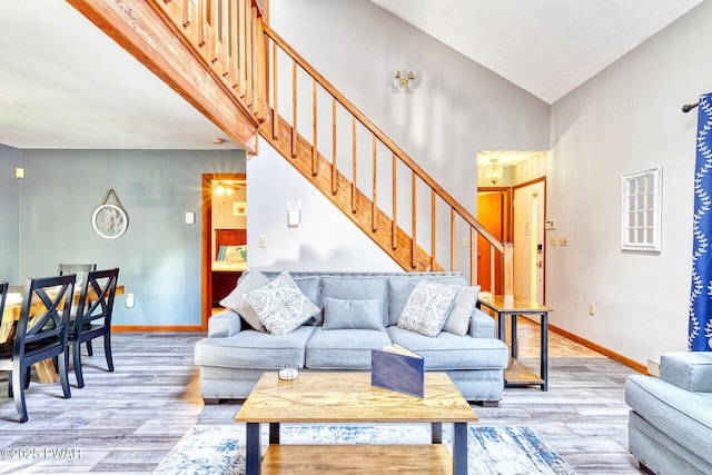 living room featuring vaulted ceiling and light hardwood / wood-style flooring