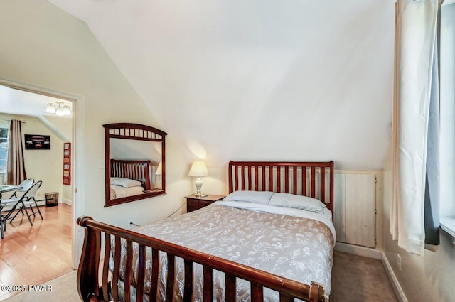 bedroom with lofted ceiling and wood-type flooring