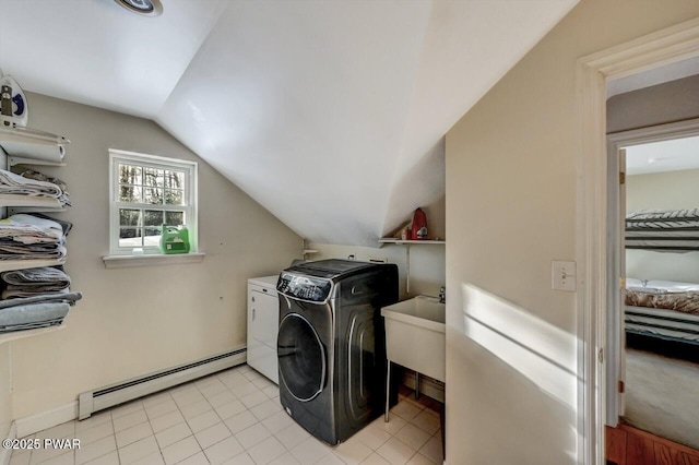 clothes washing area with independent washer and dryer, a baseboard radiator, sink, and light tile patterned floors