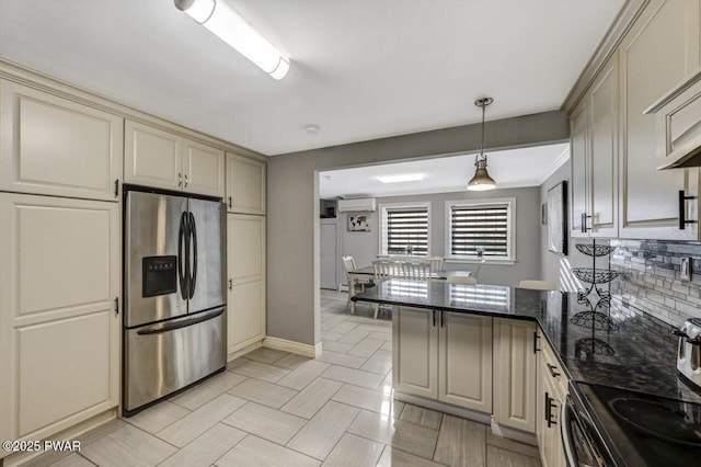 kitchen featuring a wall mounted air conditioner, pendant lighting, stainless steel fridge, dark stone counters, and electric range