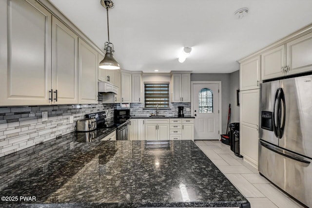 kitchen featuring pendant lighting, sink, dark stone countertops, black appliances, and custom range hood