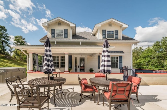 back of property featuring a hot tub and a patio