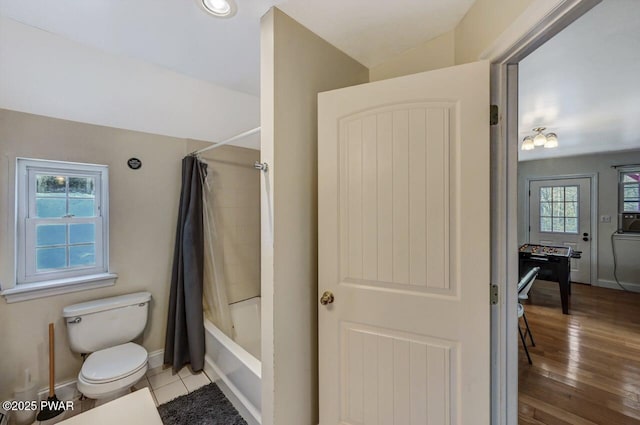 bathroom with tile patterned flooring, shower / bath combination with curtain, and toilet