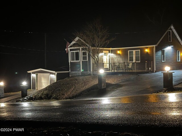 view of front of home featuring a porch and a shed