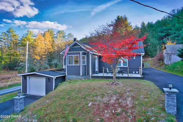 view of front of home with a garage, an outdoor structure, and a front yard