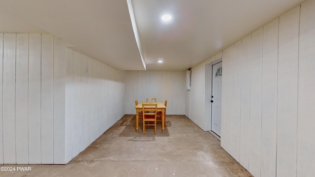 unfurnished dining area featuring wooden walls