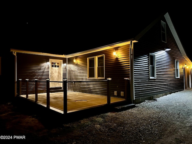 property exterior at twilight featuring a deck