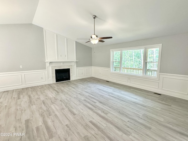 unfurnished living room featuring ceiling fan, a fireplace, light hardwood / wood-style floors, and lofted ceiling