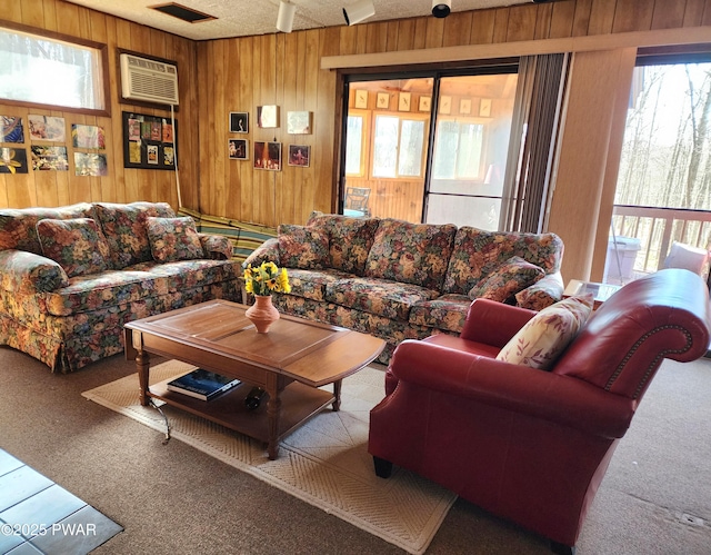 living room with wooden walls, a healthy amount of sunlight, and carpet floors