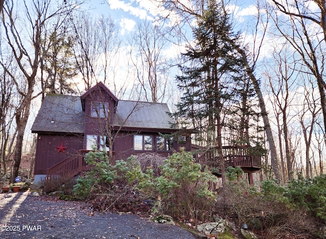 view of side of home with roof with shingles