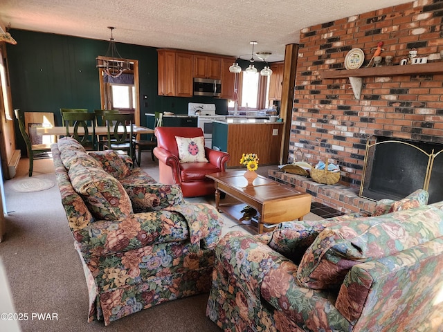 carpeted living area with a chandelier, a brick fireplace, and a textured ceiling