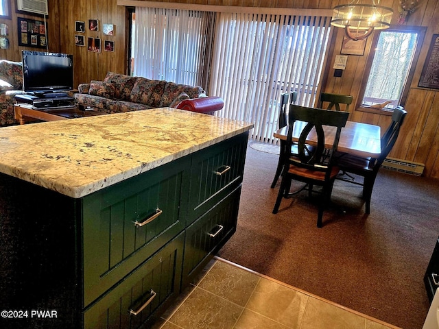 kitchen with an inviting chandelier, dark colored carpet, wood walls, and green cabinetry