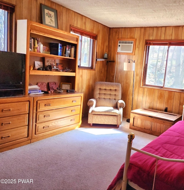 bedroom featuring an AC wall unit, carpet, wood walls, and a textured ceiling