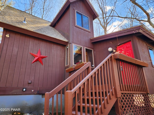 doorway to property with roof with shingles