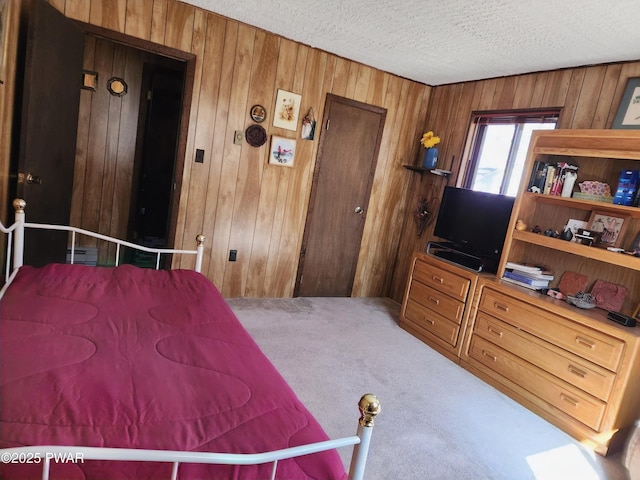 carpeted bedroom with a textured ceiling and wood walls