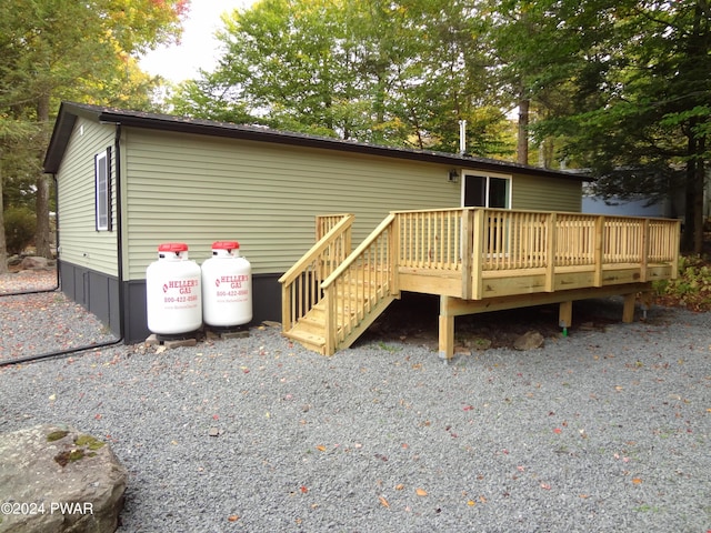 rear view of property featuring a wooden deck