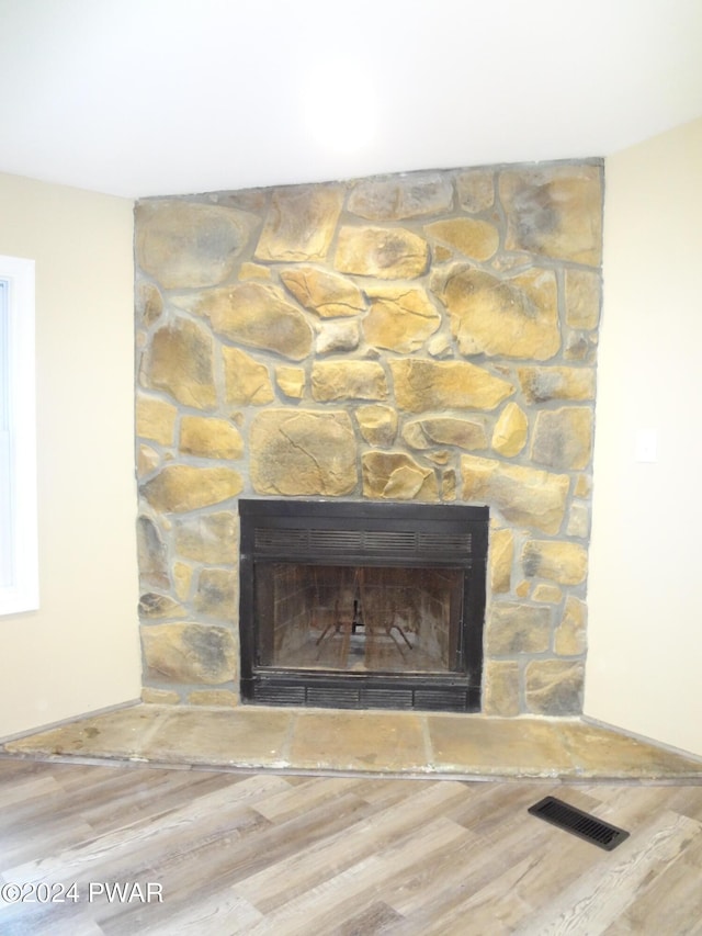 details featuring a fireplace, wood finished floors, and visible vents