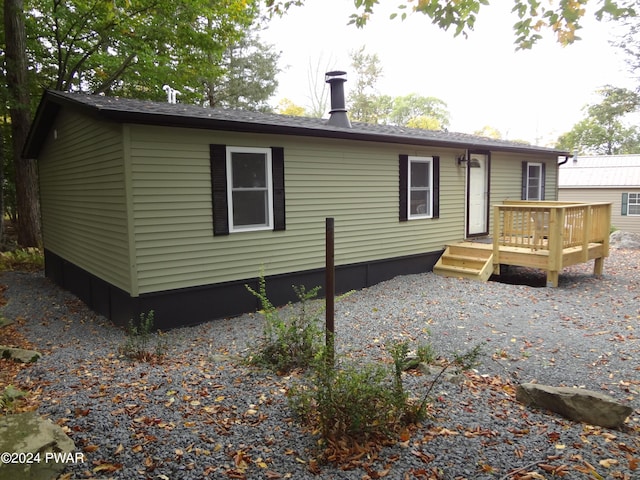 rear view of house featuring a wooden deck